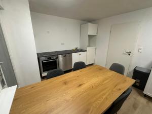 a kitchen with a wooden table and chairs at Monteurswohnung Schwarzwald in Eggingen +3 photos
