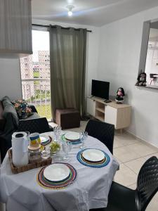 a living room with a table with plates on it at Aconchegante apartamento Sinta-se em Casa in Belém