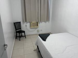 a bedroom with a bed and a chair and a window at Aconchegante apartamento Sinta-se em Casa in Belém +10 photos