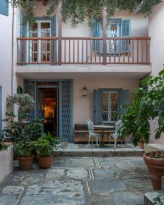 a patio with a table and a balcony at Acropolis Villa in Plaka in Athens