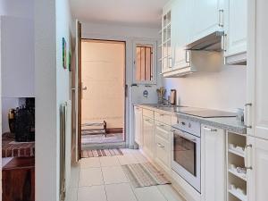 a kitchen with white cabinets and a door leading to a doorway at Apartment Vico Morcote Luxury View Apartment by Interhome in Morcote