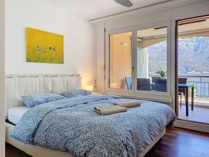 a bedroom with a bed with a large window at Apartment Vico Morcote Luxury View Apartment by Interhome in Morcote