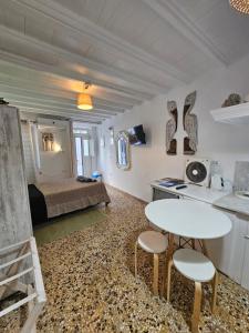 a room with a bed and a table and chairs at Petra Pelikan in Mikonos