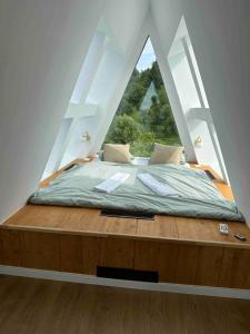 a bed in a room with a large window at Skyframe Cabin in Pucheni
