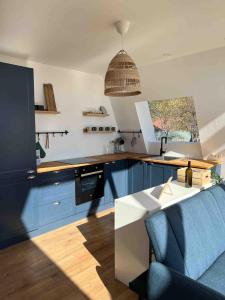 a kitchen with blue cabinets and a blue couch at Skyframe Cabin in Pucheni
