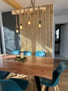 a dining room with a wooden table and blue chairs at Skyframe Cabin in Pucheni +21 photos