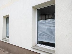 two windows with blinds on a white building at Auszeit im Vorharz in Wegeleben
