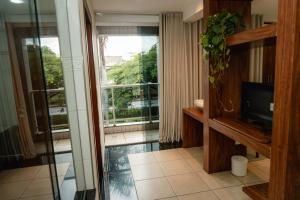 a room with a glass door and a window at Hotel Canaan in Sete Lagoas