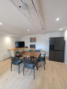 a dining room with a table and chairs and a refrigerator at Chambres des Gatinelles in Erbray