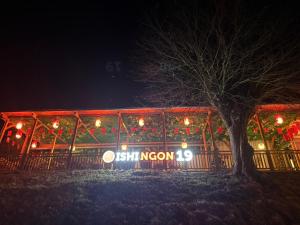 a restaurant with christmas lights and a tree at night at Oishi Ngon 19 in Wutha-Farnroda