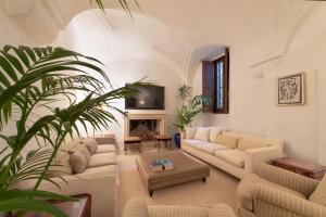 a living room with white furniture and a fireplace at Masseria Buganvillea in Fasano