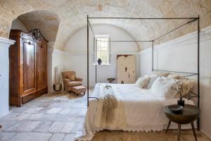 a bedroom with a large bed and a chair at Masseria Buganvillea in Fasano +28 photos