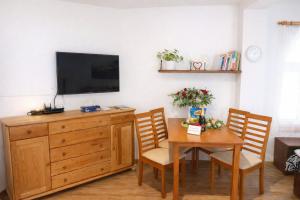 a dining room with a table and a tv on a wall at Apartmán Eskadra 1 in Horní Malá Úpa