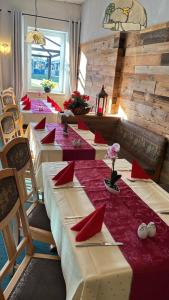 a row of tables in a restaurant with red napkins at Turmhotel Schwedt in Schwedt