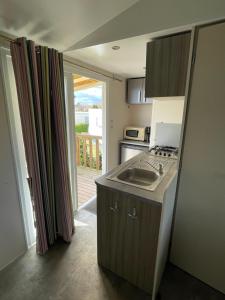 a kitchen with a sink and a stove at Le Pont Rouge & Les Vignes in Chipilly