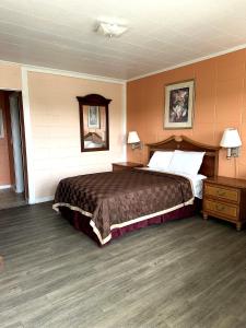 a bedroom with a large bed and a mirror at Budget Motel in Hamer