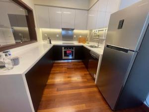 a kitchen with a refrigerator and a wooden floor at Cinnomon Life Residence Tower 20 3 in Colombo