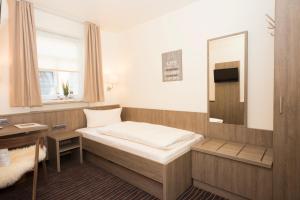mały pokój z łóżkiem i lustrem w obiekcie Hotel Mainblick Garni w mieście Marktheidenfeld