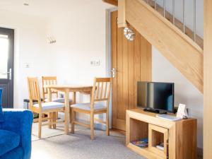 a living room with a television and a table with chairs at Chalet The Studio by Interhome in Glendale