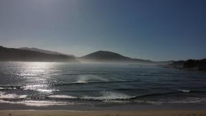 a view of a beach with mountains in the background at LAR DA REVOLTA in Cedeira