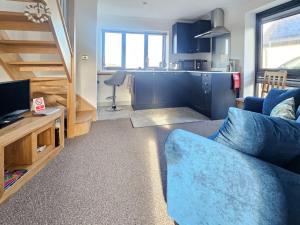 a living room with a blue couch and a kitchen at Chalet The Studio by Interhome in Glendale