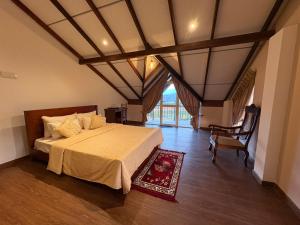 a bedroom with a large bed and a chair at 7 Crowns Villa Ambewela, Nuwara Eliya in Boragasketiya