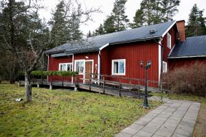 una casa rossa con tetto nero di Mellangården a Västerbykil