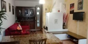a kitchen and living room with a table and a refrigerator at Casa vacanze Malinini in Savogna