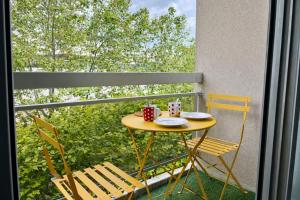a small table and two chairs on a balcony at Relax-Parc des expos-Wifi by La clé des expos in Vanves