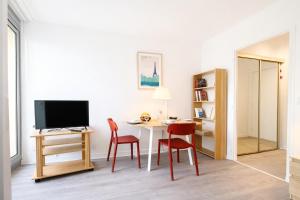 a room with a table and two chairs and a television at Relax-Parc des expos-Wifi by La clé des expos in Vanves