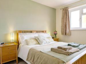 a bedroom with a large white bed with a window at Orchard Mews , Barnham in Barnham