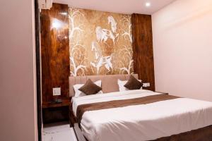 a bedroom with a large bed with a wall mural at hotel kargil inn in Satna