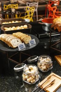 a display of different types of bread and pastries at Aera São José Floripa - Hotel com café da manhã a 10 min do CentroSul in São José