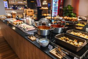 a buffet line with different types of food on it at Aera São José Floripa - Hotel com café da manhã a 10 min do CentroSul in São José