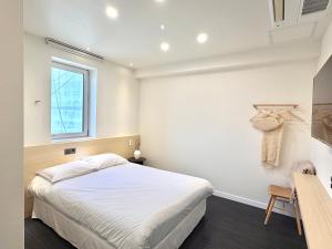 a bedroom with a white bed and a window at Unplug Anguk in Seoul