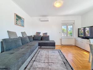 a living room with a couch and a television at Apartment Rilić-3 by Interhome in Zaostrog