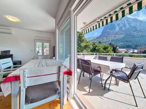 a dining room with a table and chairs and a balcony at Apartment Rilić-3 by Interhome in Zaostrog +22 photos