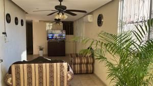 a living room with a couch and a ceiling fan at Casa Aca in Acapulco