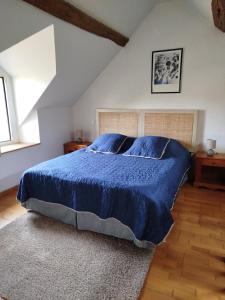 a bedroom with a bed with a blue comforter at Petite parenthèse au gîte Layon in Les Garennes sur Loire +24 photos