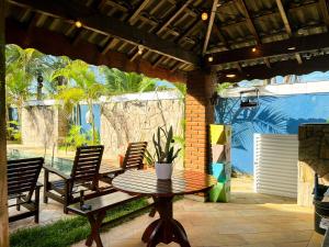 a patio with a table and chairs under a pavilion at Casarão Dos Santos - Guest House in Peruíbe +54 photos