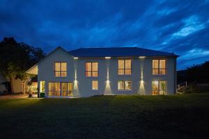 a white house with lights on the front of it at GästeHaus Auler Hof in Kröv