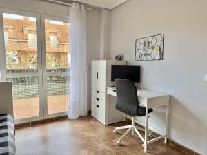 an office with a desk and a computer and a window at Casa El Robledal 5925 in Arnuero