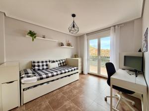 a bedroom with a bed and a desk and a computer at Casa El Robledal 5925 in Arnuero +7 photos