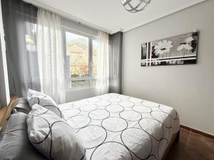a bedroom with a bed and a couch and a window at Casa El Robledal 5925 in Arnuero
