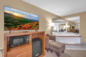 a living room with a television and a bath tub at Bristol Arcadia Inn in Bristol