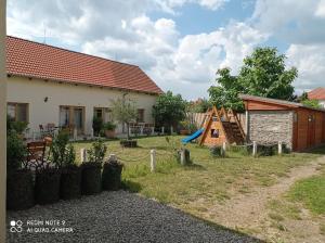 a house with a yard with a playground at Apartmány Amaris in Strachotín