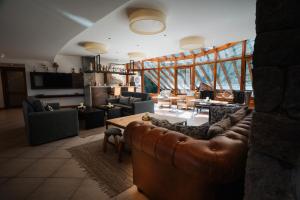 a living room with a leather couch and a table at Sol Arrayan Hotel & Spa in Villa La Angostura