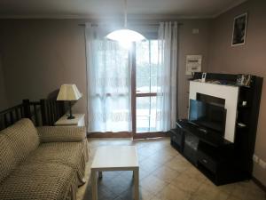 a living room with a couch and a television at Good Time house in Aprilia Marittima