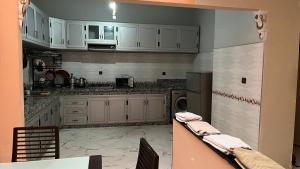a kitchen with white cabinets and a dishwasher at AMAZIGH BIG Family APARTMENT in Meknès