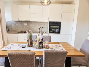 a kitchen with a wooden table with bottles and flowers on it at Apartment Paz by Interhome in Donji Proložac
